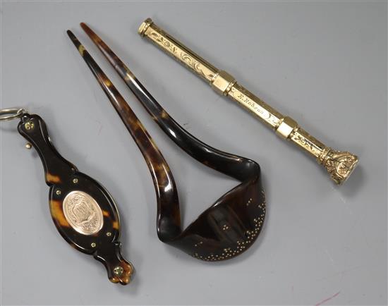 An early 20th century yellow metal overlaid propelling pen and two tortoiseshell items including a hair comb.